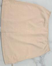Jupe beige tissu souple, courte tirette dans le dos, ouverte sur un côté fermé par deux lacets (taille 44)