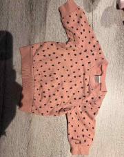 Pull rose avec tache noir 